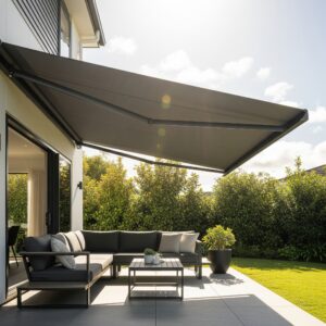 A dark grey Mblinds retractable awning extended over a modern patio in New Zealand on a sunny day.